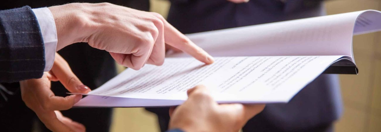 Cropped view of businesswomen reading document. Closeup shot of female finger pointing at page. Business concept